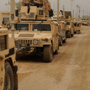 Convoy of military vehicles in desert battlefield